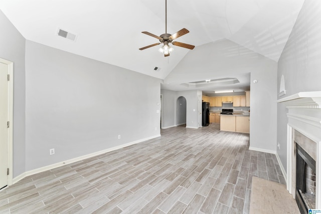 unfurnished living room featuring visible vents, baseboards, wood tiled floor, a fireplace, and arched walkways