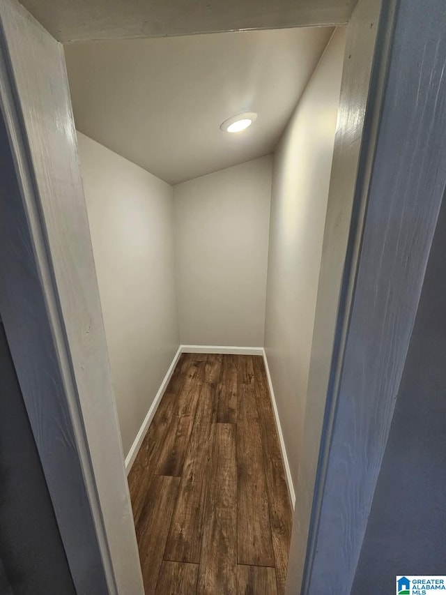 hall featuring baseboards and dark wood-style flooring