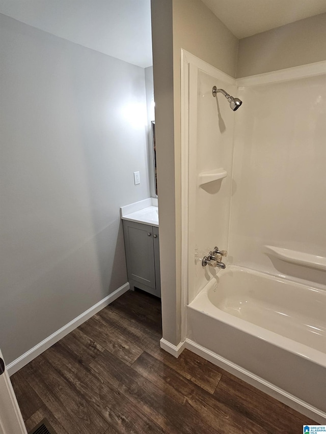 full bathroom with vanity, shower / tub combination, baseboards, and wood finished floors