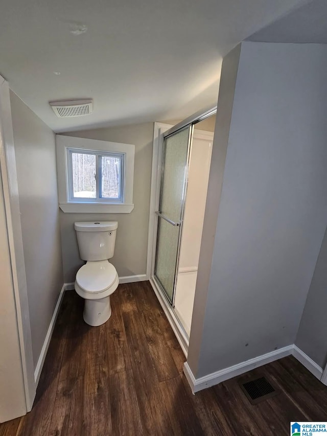 full bath with wood finished floors, baseboards, visible vents, a stall shower, and toilet