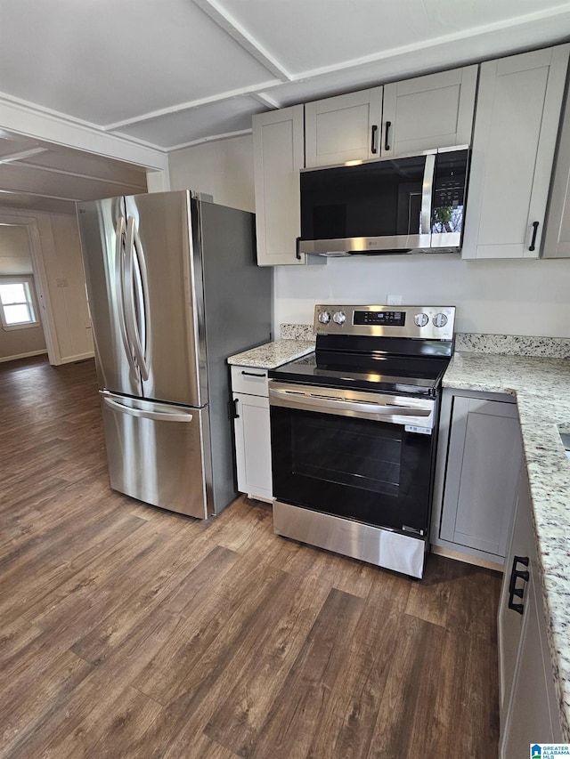 kitchen featuring light stone countertops, dark wood-style floors, and appliances with stainless steel finishes