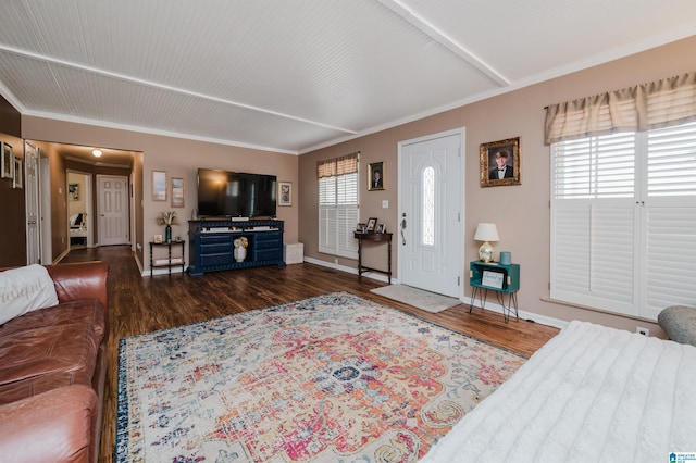 living area with a wealth of natural light, dark wood-style floors, crown molding, and baseboards