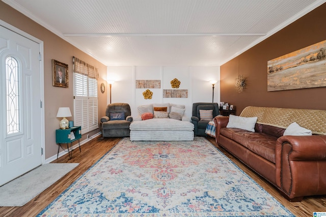 living area with wood finished floors, baseboards, and ornamental molding