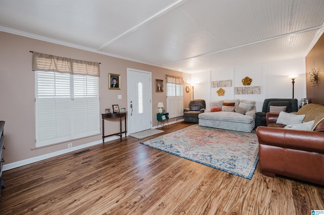 living room with visible vents, baseboards, wood finished floors, and ornamental molding