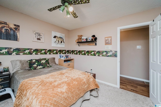 carpeted bedroom with ceiling fan, baseboards, and a textured ceiling