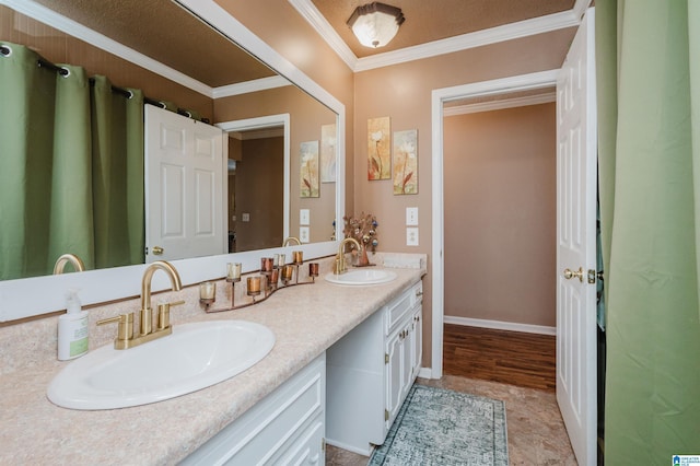 bathroom with double vanity, ornamental molding, baseboards, and a sink