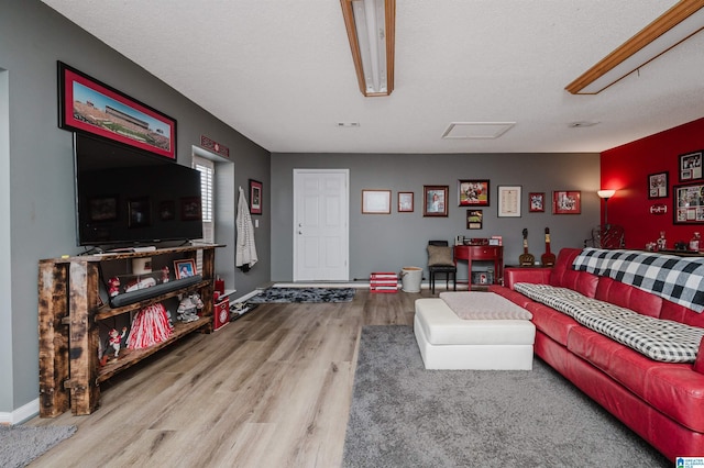 living area with baseboards and wood finished floors