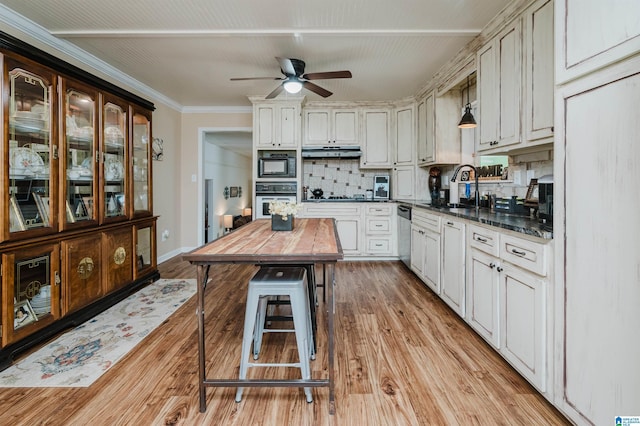 kitchen featuring oven, butcher block countertops, a sink, under cabinet range hood, and black microwave