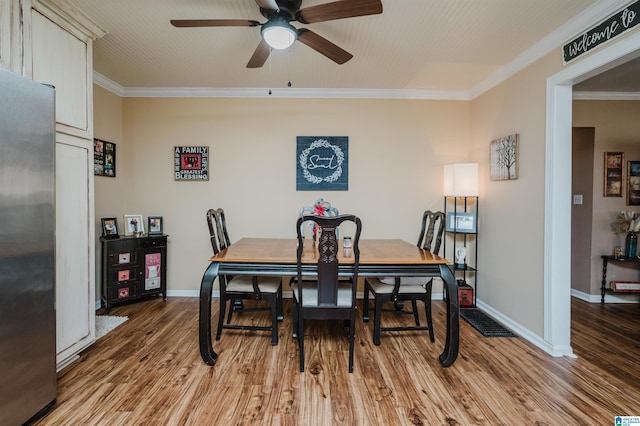 dining area with wood finished floors, baseboards, and ornamental molding