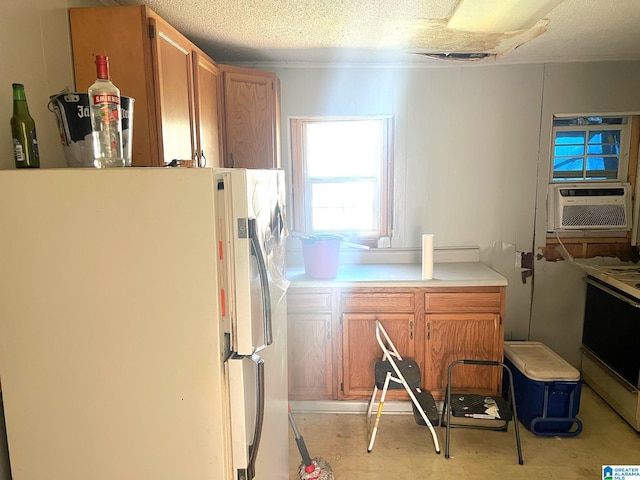 kitchen featuring light countertops, cooling unit, freestanding refrigerator, and a textured ceiling