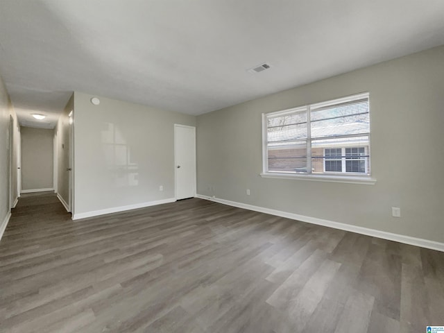 empty room with visible vents, baseboards, and wood finished floors