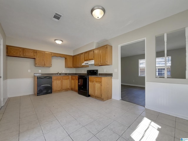 kitchen with light tile patterned floors, visible vents, a sink, black appliances, and under cabinet range hood