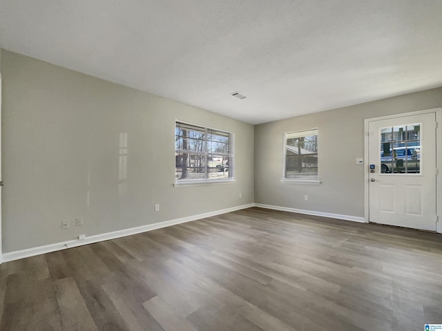 interior space featuring dark wood finished floors, visible vents, and baseboards