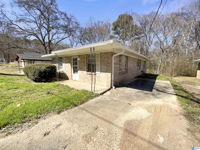 view of side of property with brick siding and driveway