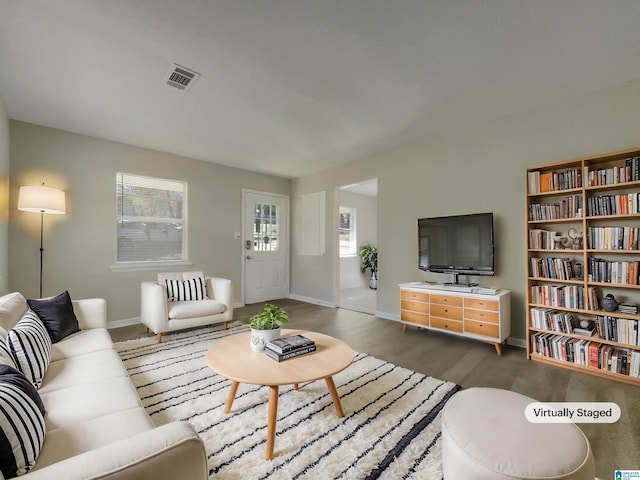 living room with visible vents, baseboards, and wood finished floors