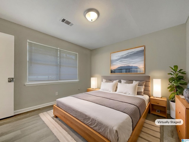 bedroom featuring wood finished floors, visible vents, and baseboards