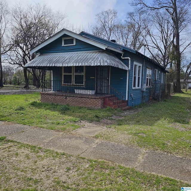 view of front of property with covered porch and a front lawn