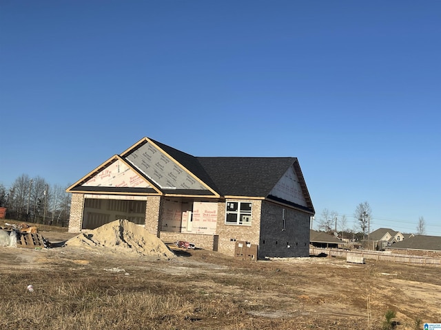 unfinished property featuring brick siding and an attached garage