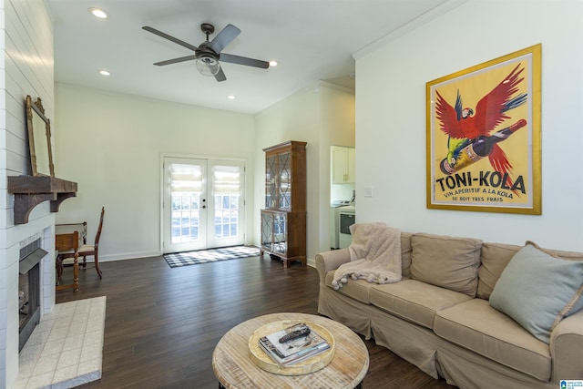 living room with dark wood-style floors, baseboards, a fireplace, ornamental molding, and french doors