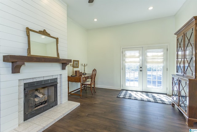 living area featuring dark wood finished floors, french doors, a tile fireplace, and ornamental molding