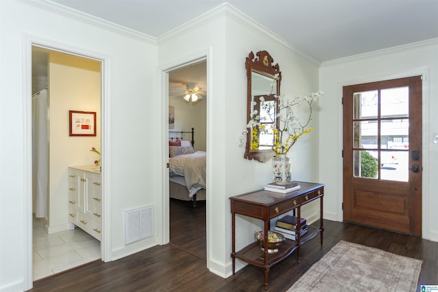 entrance foyer with visible vents, dark wood-type flooring, baseboards, and ornamental molding