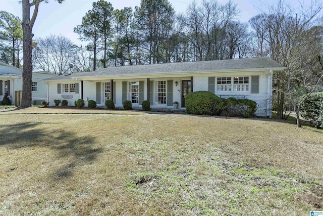 ranch-style home featuring brick siding and a front lawn