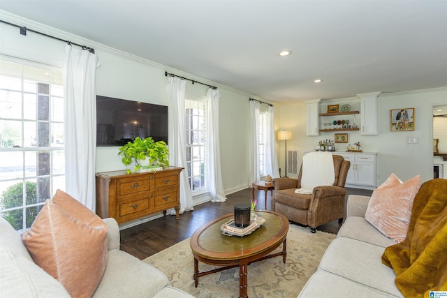 living area with recessed lighting, wood finished floors, visible vents, and ornamental molding