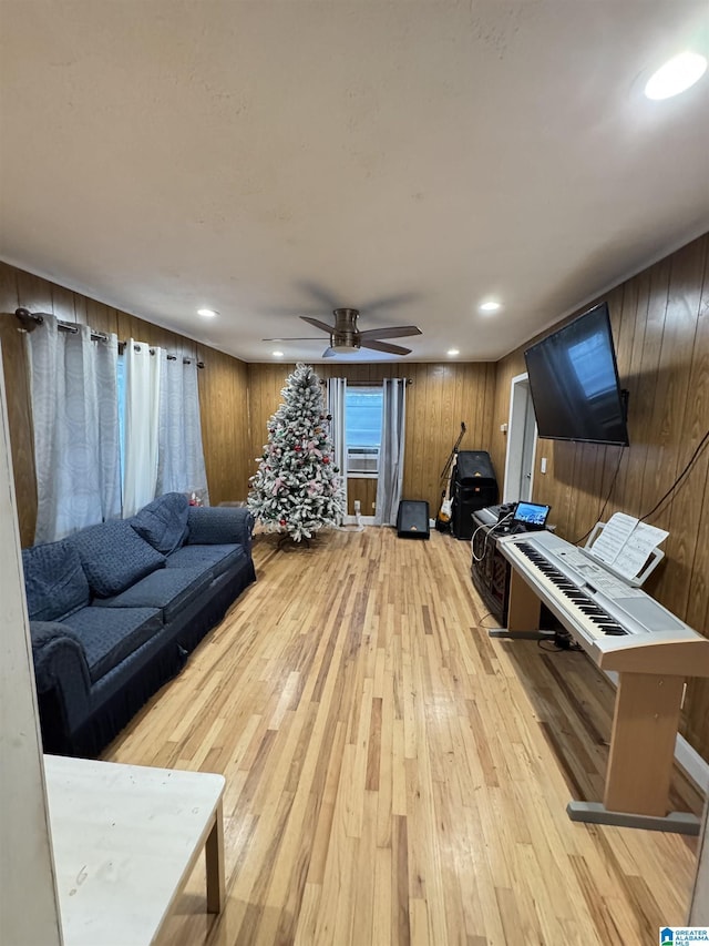 living room with wooden walls, recessed lighting, and light wood-style floors