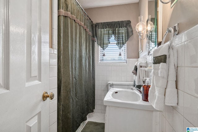 full bath with curtained shower, tile walls, and vanity