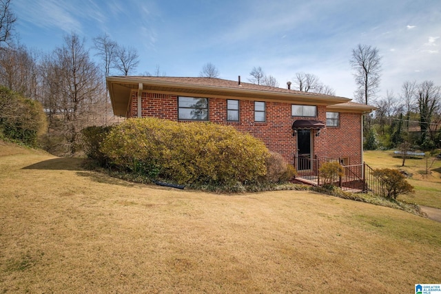 view of front of home featuring brick siding and a front yard