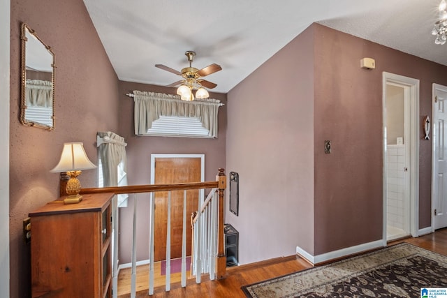 staircase featuring ceiling fan, baseboards, and wood finished floors