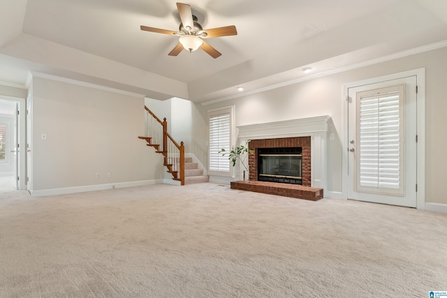 unfurnished living room with crown molding, a raised ceiling, and carpet