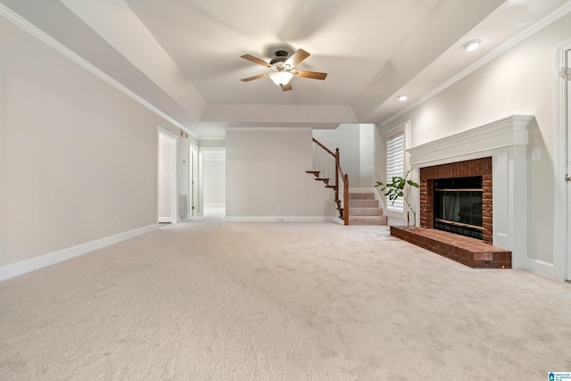 unfurnished living room with a ceiling fan, baseboards, carpet floors, a tray ceiling, and stairs