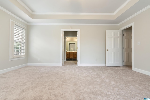 unfurnished bedroom featuring a raised ceiling, crown molding, baseboards, and light carpet