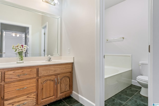 bathroom with baseboards, toilet, vanity, and tile patterned flooring