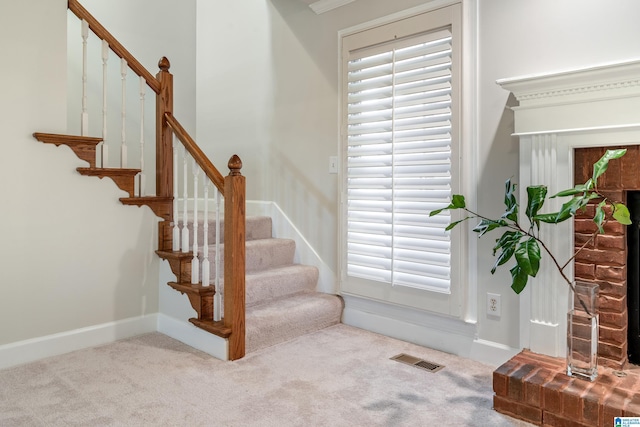 stairway with visible vents, baseboards, and carpet