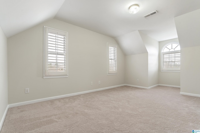 bonus room featuring visible vents, plenty of natural light, carpet, and vaulted ceiling