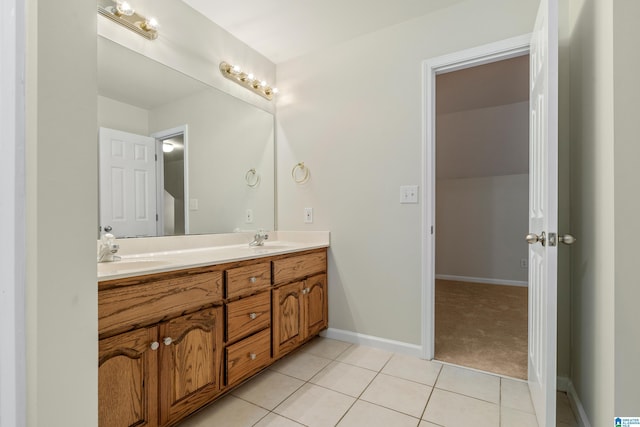 full bathroom featuring tile patterned flooring, double vanity, baseboards, and a sink