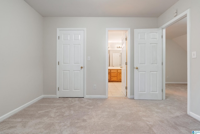 unfurnished bedroom featuring baseboards, carpet floors, and connected bathroom