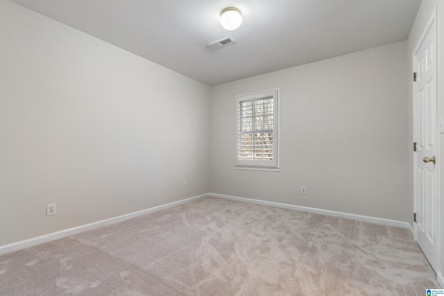 spare room with visible vents, light colored carpet, and baseboards