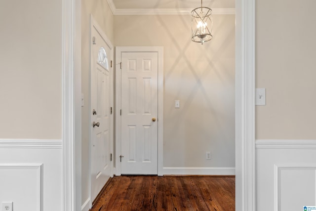 interior space featuring a notable chandelier, baseboards, dark wood-type flooring, and crown molding