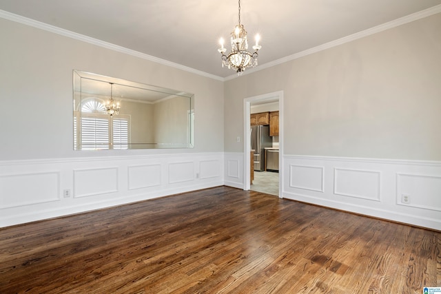 spare room with a chandelier, dark wood finished floors, wainscoting, and ornamental molding