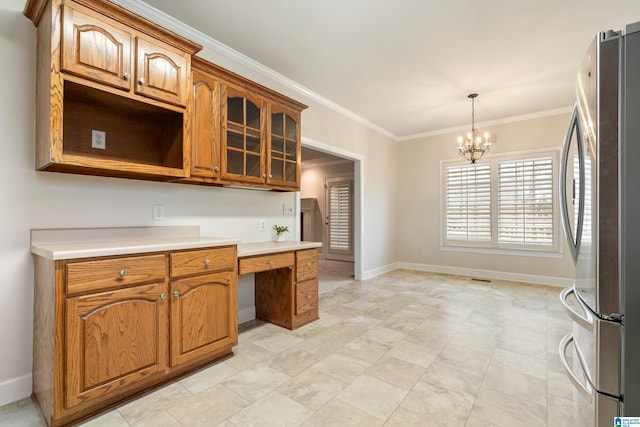 kitchen with freestanding refrigerator, brown cabinetry, light countertops, crown molding, and built in study area