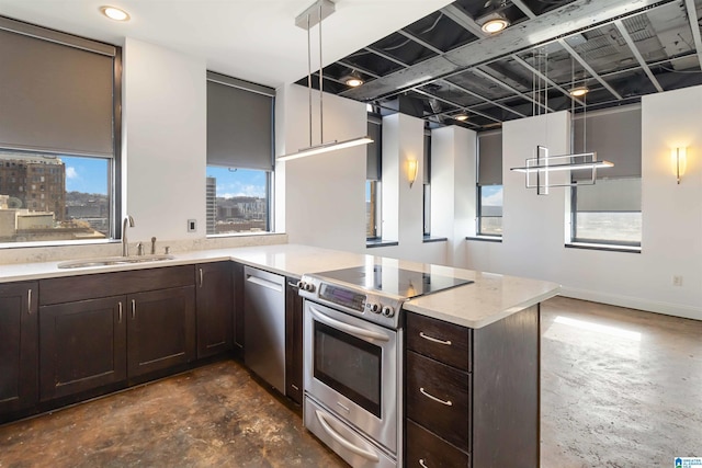 kitchen with dark brown cabinets, decorative light fixtures, a peninsula, stainless steel appliances, and a sink