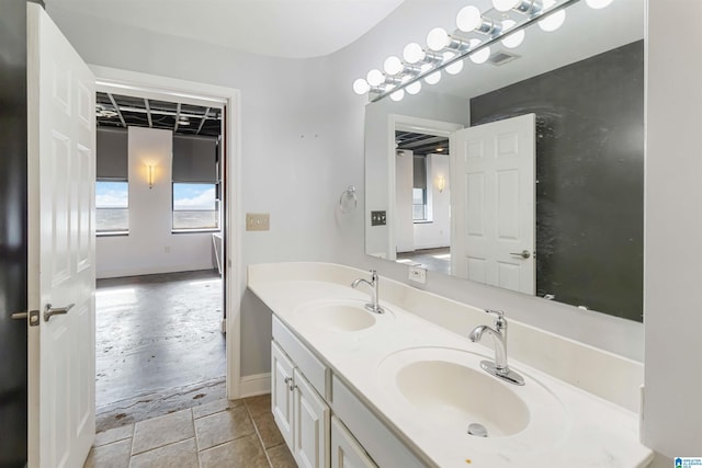 bathroom with double vanity, baseboards, and a sink