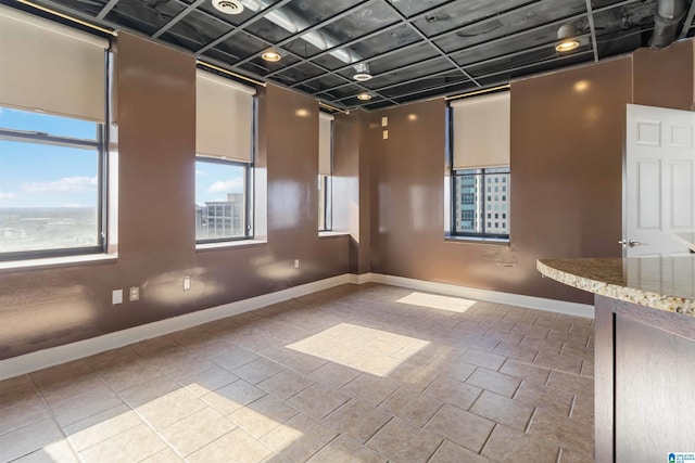 unfurnished room with tile patterned floors and baseboards