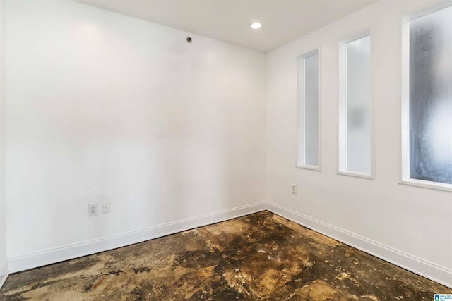 spare room with recessed lighting, baseboards, and concrete flooring