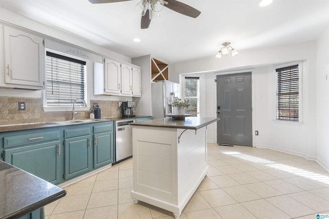 kitchen with light tile patterned floors, plenty of natural light, a sink, white refrigerator with ice dispenser, and stainless steel dishwasher