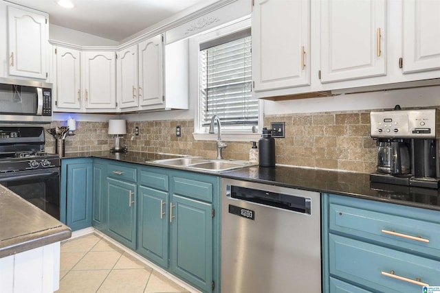 kitchen with blue cabinetry, white cabinetry, stainless steel appliances, and a sink