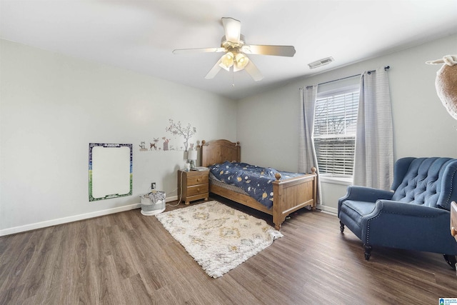 bedroom with visible vents, ceiling fan, baseboards, and wood finished floors